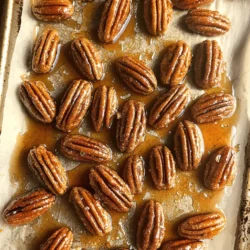 - 2 cups pecan halves - 1/4 cup pure maple syrup - 1 teaspoon ground cinnamon - 1/2 teaspoon salt - 1/4 teaspoon nutmeg (optional) - 1 tablespoon unsalted butter (melted) - 1 teaspoon vanilla extract - 1/2 cup granulated sugar - Mixing bowl - Baking sheet - Parchment paper - Measuring cups and spoons Pecans are full of healthy fats, protein, and fiber. They help your heart and brain. Each serving gives you vitamins and minerals. Maple syrup is tasty and has antioxidants. It can help keep you healthy too. Using pure maple syrup is key for flavor. It has less sugar than other sweeteners. Pecans also have magnesium, which helps with muscle and nerve function. They can lower bad cholesterol levels. Together, these ingredients make a tasty snack that is good for you. Enjoy them in moderation for the best health benefits. You can find the full recipe above to try these delicious treats! Preheat your oven to 350°F (175°C). This step is key for perfect roasting. Line a baking sheet with parchment paper to prevent sticking. In a mixing bowl, combine the melted butter, pure maple syrup, vanilla extract, ground cinnamon, and salt. If you like, add nutmeg for extra flavor. Stir well until everything mixes together smoothly. Add 2 cups of pecan halves to the bowl. Toss them in the maple syrup mixture until they are fully coated. This ensures every nut gets that sweet flavor. Next, sprinkle 1/2 cup of granulated sugar over the pecans. Stir to mix the sugar evenly. This adds a nice sweetness and crunch to your pecans. Spread the coated pecans evenly on the prepared baking sheet in a single layer. Roast them in the preheated oven for 15-20 minutes. Stir the nuts every 5 minutes. This helps them cook evenly and prevents burning. You’ll know they are done when they turn golden brown and smell great. Once they are ready, take them out and let them cool on the sheet. They will become crisp as they cool. Enjoy your tasty maple cinnamon roasted pecans! For the full recipe, refer back to the ingredients and instructions provided. To avoid burnt nuts, keep a close eye on the oven. Stir the pecans every five minutes. This helps them roast evenly. If you smell a strong aroma, check them right away. Remove them from the oven when they turn golden brown. To achieve optimal crispiness, let the pecans cool completely on the baking sheet. They will harden as they cool. This step is key for that satisfying crunch. If you want alternatives for maple syrup, try honey or agave nectar. They give a sweet touch too. For spices, you can use pumpkin pie spice or allspice. These add a warm flavor twist to your pecans. For extra flavor, add a pinch of cayenne pepper or smoked paprika. These spices offer a nice kick. You can also mix in extracts like almond or coconut. They bring a unique taste to the mix. Combining with other nuts, like almonds or walnuts, adds texture and depth. This mix can make your snack even more enjoyable. Remember to adjust the roasting time based on nut size. For the full recipe, check the main article. Enjoy your tasty maple cinnamon roasted pecans! {{image_2}} You can change up the flavors with sweet twists. Try chocolate maple cinnamon pecans. Just add melted chocolate to your maple syrup mix. This gives a rich, sweet taste that pairs well with the crunchy pecans. Another fun option is maple vanilla pecan clusters. Mix in vanilla extract with the syrup for a creamy flavor. These treats are great for snacking or gifting! If you want savory nuts, try spicy maple pecans. Add cayenne pepper or paprika to the maple syrup mix for a kick. This gives you a sweet and spicy treat that is hard to resist. Another option is maple herb roasted pecans. Mix in dried herbs like rosemary or thyme. The herbs add a fresh taste that balances the sweetness of the maple. You can make these treats fit your diet too. For vegan-friendly options, swap the butter with coconut oil or skip it entirely. The recipe still works well without it. If you're looking for low-sugar alternatives, use less granulated sugar. You can also use a sugar substitute like stevia or monk fruit. This way, you enjoy the flavors without the extra sugar. For the full recipe, check out the ingredients and instructions. Enjoy making your own variations of maple cinnamon roasted pecans! To keep your roasted pecans fresh, use airtight containers. This helps to lock in their crunch and flavor. Store them in a cool, dry place. If stored properly, these pecans will stay good for up to two weeks. You can freeze roasted pecans for longer storage. First, place them in a freezer-safe bag or container. Remove as much air as possible. They can last for about three months in the freezer. To enjoy them later, thaw the pecans in the fridge overnight before using. Maple cinnamon roasted pecans are great on their own as a snack. They also pair well with desserts like ice cream or yogurt. Try adding them to salads for a nice crunch. Use them as toppings on oatmeal or pancakes for extra flavor. Store your maple cinnamon roasted pecans in an airtight container. This keeps them fresh and crunchy. You can place them in a cool, dry spot. Avoid direct sunlight and heat to maintain their flavor. If you want them to last longer, you can refrigerate them. Yes, you can make these pecans ahead of time. Prepare the pecans and let them cool completely. Once cooled, place them in an airtight container. They will stay fresh for several days. This makes them perfect for parties or snacks on the go. If your pecans burn, don’t worry! You can try to salvage them. First, let them cool. Then, gently break off any burnt pieces. If they taste too bitter, you may need to start over with fresh pecans. Always keep an eye on them while roasting. Yes, pecans offer many health benefits. They are rich in healthy fats, protein, and fiber. Pecans also contain vitamins and minerals like vitamin E and magnesium. Eating them can help with heart health and may support weight management. Maple cinnamon roasted pecans can last about two weeks when stored properly. If you keep them in an airtight container, they stay fresh longer. Always check for any signs of spoilage before eating them. Enjoy your pecans as a tasty snack or topping! For the full recipe, check out the earlier section. In this post, we explored how to make delicious roasted pecans. We discussed the ingredients needed, both required and optional, and shared tips for preparing and roasting. You learned about healthy benefits and exciting variations to try. Each step aimed to guide you in making pecans at home. In conclusion, roasting pecans is simple and fun. Enjoy the tasty results and share them with friends. Experiment with flavors to make your own unique snacks. Happy roasting!