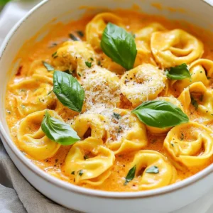 - 2 cups cheese tortellini (fresh or frozen) - 1 can (14 oz) crushed tomatoes - 1 cup heavy cream - 1 medium onion, diced - 3 cloves garlic, minced - 1 tablespoon olive oil - 1 teaspoon dried basil - 1 teaspoon dried oregano - 1/2 teaspoon red pepper flakes (optional) - Salt and pepper to taste - Fresh basil leaves for garnish - Grated parmesan cheese for serving You can use either fresh or frozen tortellini. Fresh tortellini cooks faster. It usually needs about 2-3 minutes. Frozen tortellini takes longer, about 5-7 minutes. Both options taste great in this dish. If you choose frozen, make sure to cook it until tender. Feel free to mix up the cheeses. Try ricotta or mozzarella for a twist. You can also add herbs like thyme or parsley. These will add more flavor. Fresh basil is perfect for garnish. It brightens the dish and adds color. Grated parmesan on top enhances the taste too! {{ingredient_image_1}} Start by heating olive oil in a large skillet over medium heat. Add the diced onion. Saut&eacute; the onion until it becomes soft and clear, about 5 minutes. Next, add the minced garlic. Cook it for 1-2 minutes until it smells great. Now, pour in the crushed tomatoes along with their juices. Stir in dried basil and oregano. For a little heat, add red pepper flakes if you like. Let the sauce simmer gently for about 5-7 minutes. While the sauce simmers, cook the tortellini as directed on the package. Fresh or frozen tortellini works well here. Once cooked, drain the tortellini and set it aside. This step is crucial, as it ensures the pasta is ready to mix with the sauce. Once the tomato sauce has simmered, lower the heat. Gradually stir in the heavy cream. Let it cook for another 3-4 minutes while stirring. This makes the sauce nice and creamy. Now, add the cooked tortellini to your skillet. Gently toss the tortellini until they are well coated in the sauce. Season with salt and pepper to taste. Cook everything together for an additional 2-3 minutes until it is warm. Now, your creamy tomato tortellini skillet is ready to serve! To make your sauce extra creamy, use heavy cream. This cream gives a rich taste. You can also mix in some cream cheese. Just add a few spoonfuls when you stir in the cream. This adds even more creaminess and flavor. If you want more heat, add more red pepper flakes. Start with a pinch, then taste. You can also try fresh herbs. Fresh basil can enhance the dish. Just tear the leaves and stir them in at the end. This adds freshness and a nice pop of color. To make your meal look great, use a large bowl. Serve the tortellini hot, and add fresh basil on top. A sprinkle of grated parmesan cheese adds elegance. You can also drizzle a little olive oil for shine. This makes the dish more appealing for you and your guests. Pro Tips Use Fresh Ingredients: Whenever possible, opt for fresh tortellini and herbs to enhance the overall flavor of the dish. Customize the Spice Level: Adjust the amount of red pepper flakes to your preference; omit them entirely for a milder dish. Make it Ahead: This dish can be made ahead of time and reheated; just add a splash of cream to revive the sauce's creaminess. Garnish for Presentation: A sprinkle of freshly grated parmesan and torn basil leaves not only adds flavor but also makes the dish visually appealing. {{image_2}} You can boost the nutrition by adding vegetables. Spinach, zucchini, or bell peppers work great. Just chop them small and add them after the onion. Saut&eacute; them for a few minutes until they soften. This adds color and fiber to your dish. For a heartier meal, add protein like chicken or sausage. Cook the chicken in the skillet before the onion. Cut it into bite-sized pieces. If you prefer sausage, slice it and cook it until brown. Then, add the onion and garlic as normal. This adds flavor and makes the meal more filling. Switching up the sauce can make the dish exciting. Try adding pesto for a fresh twist. You can also use Alfredo sauce for a creamier texture. Mix in a bit of balsamic glaze for a sweet and tangy kick. These changes give the dish new life and keep it fun. To store your creamy tomato tortellini skillet, let it cool first. Use an airtight container. This keeps it fresh and tasty. You can store it in the fridge for up to three days. Make sure to label it with the date. This way, you will know when to eat it. When you want to enjoy it again, take it out of the fridge. You can reheat it on the stove or in the microwave. If using the stove, place it in a pan over low heat. Stir it often until it's hot. If using the microwave, cover it and heat in short bursts. Stir after each burst. Be careful not to overheat, as it can dry out. You can freeze the creamy tomato tortellini skillet too. To freeze, let it cool and then transfer to a freezer-safe container. It will stay good for up to three months. When you want to eat it, thaw it in the fridge overnight. Then, reheat it on the stove or microwave as mentioned above. This will help retain the flavor and creaminess. Yes, you can use non-dairy cream. Coconut cream or cashew cream works well. These options add a nice flavor. They also keep your dish creamy. Just use the same amount as heavy cream. Cooking frozen tortellini takes about 5-7 minutes. Boil water and add the tortellini. Stir them gently to avoid sticking. They are cooked when they float to the top. Always check the package for exact cooking times. You can serve this dish with garlic bread or a fresh salad. Both complement the creamy sauce. A side of steamed vegetables adds more nutrition. For a fun twist, try serving it with a light pesto drizzle. This blog post explored the world of creamy tomato tortellini. We covered key ingredients, from fresh to frozen tortellini, and cheese options. I shared step-by-step instructions for easy preparation and tips for a creamy sauce. You learned about variations to add nutrition and flavor and storage tips for leftovers. In conclusion, making this dish is simple and fun. Experiment with flavors and enjoy your tasty results. With the right ingredients and tips, you can create a meal everyone will love.