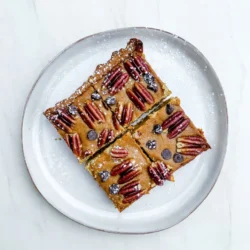 To make these delicious pumpkin pecan pie bars, gather the following ingredients: - 1 &frac12; cups all-purpose flour - &frac12; cup brown sugar - &frac12; cup unsalted butter, softened - 1 cup canned pumpkin puree - 1 cup sweetened condensed milk - &frac12; cup granulated sugar - 2 large eggs - 1 teaspoon vanilla extract - 1 teaspoon ground cinnamon - &frac12; teaspoon ground nutmeg - &frac12; teaspoon ground ginger - &frac12; teaspoon salt - 1 cup pecans, roughly chopped - &frac12; cup mini chocolate chips (optional) Each ingredient plays a role in making these bars tasty. The flour and butter make a great crust. The pumpkin puree gives the filling its rich flavor and smooth texture. You can swap some ingredients based on what you have at home. Here are some ideas: - Use coconut oil instead of butter for a dairy-free crust. - Swap granulated sugar for coconut sugar to add a hint of caramel flavor. - If you don't have pecans, try walnuts or almonds instead. - You can use any sweet milk alternative for sweetened condensed milk. These substitutions can help you make the recipe work for your needs. Using fresh ingredients makes a big difference in flavor. Fresh eggs help create a light texture. Fresh spices, like cinnamon and nutmeg, add more depth than older ones. While canned pumpkin is convenient, check the label for quality. When it comes to pecans, use whole or roughly chopped ones for the best taste. If you can, buy them whole and chop them yourself. This step will enhance the flavor of your pumpkin pecan pie bars. Fresh ingredients truly make these bars irresistible! {{ingredient_image_1}} First, preheat your oven to 350&deg;F (175&deg;C). This step is key to getting that perfect bake. Next, grease a 9x13 inch baking pan. You can also line it with parchment paper. This makes it easy to remove the bars later. In a medium bowl, mix 1 &frac12; cups of flour with &frac12; cup of brown sugar. Then, add &frac12; cup of softened butter. Use your fingers to mix until it feels like coarse crumbs. This texture is important for a nice crust. Press the mixture evenly into the bottom of your baking pan. In a large bowl, combine 1 cup of canned pumpkin puree and 1 cup of sweetened condensed milk. Add &frac12; cup of granulated sugar, 2 large eggs, and 1 teaspoon of vanilla extract. Then, sprinkle in 1 teaspoon of ground cinnamon, &frac12; teaspoon of ground nutmeg, &frac12; teaspoon of ground ginger, and &frac12; teaspoon of salt. Whisk everything together until smooth. This filling is where the magic happens! Now, stir in 1 cup of roughly chopped pecans. If you like chocolate, add &frac12; cup of mini chocolate chips too. This will give your bars a sweet twist. Pour the filling over your pre-baked crust. Spread it out evenly with a spatula. Bake everything for 25-30 minutes. You know it's done when a toothpick comes out clean from the center. Once baked, let the bars cool completely in the pan on a wire rack. Chill them in the fridge for 1-2 hours. This helps them set up nicely. When ready to serve, cut them into squares. For a touch of fun, dust with powdered sugar or add whipped cream on top. Enjoy your delicious bars! To make your bars perfect, follow these tips: - Use fresh ingredients. Fresh eggs and good pumpkin puree make a big difference. - Measure accurately. Use measuring cups and spoons for precision. This helps the texture. - Cool the crust. Let the crust cool slightly before adding the filling. This keeps it crisp. - Check baking time. Ovens vary, so check your bars a few minutes early. They should be set and a toothpick should come out clean. Here are some mistakes to watch out for: - Overmixing the filling. Mix just until combined to avoid tough bars. - Skipping the cooling step. Don't rush to cut the bars; cooling helps them set. - Not greasing the pan. Always grease or use parchment paper to avoid sticking. - Using stale nuts. Make sure your pecans are fresh for the best flavor. For a lovely serving, try these ideas: - Cut into uniform squares. This makes the bars look neat and inviting. - Top with whipped cream. A dollop of cream adds a nice touch. - Sprinkle cinnamon. A dusting of cinnamon gives a beautiful finish. - Serve on a festive plate. Use your best dishware to make it special, especially for gatherings. Pro Tips Check the Pumpkin: Ensure you use pure pumpkin puree, not pumpkin pie filling, to control sweetness and spices. Chill for Best Results: Refrigerating the bars for a couple of hours helps them set better, making them easier to cut. Perfectly Baked Crust: Watch the crust as it bakes; it should be lightly golden but not overly browned to avoid a tough texture. Nut Variations: Feel free to substitute pecans with walnuts or almonds for a different flavor twist. {{image_2}} To make vegan pumpkin pecan pie bars, swap the eggs and butter. Use flax eggs instead of regular eggs. Mix one tablespoon of flaxseed meal with three tablespoons of water for each egg. For butter, use coconut oil or a vegan butter alternative. The rest of the ingredients stay the same. This way, you keep all the flavor while making it plant-based. If you need gluten-free bars, replace all-purpose flour with a gluten-free flour blend. Look for blends that have xanthan gum for better structure. This change allows everyone to enjoy the bars without gluten. Ensure all other ingredients, like baking powder, are gluten-free as well. You can spice up your bars with different flavors. Try adding a pinch of ground cloves for depth. You can also mix in chocolate chips for a sweet twist. If you love a nutty taste, toss in walnuts with the pecans. Each addition gives a new twist to this classic treat. Feel free to experiment with your favorite spices and nuts. This way, every batch can be a fun surprise! To keep your Pumpkin Pecan Pie Bars fresh, place them in an airtight container. You can layer the bars with parchment paper to prevent sticking. Store the container in the fridge. This helps maintain their flavor and texture for a longer time. You can also freeze these bars for later enjoyment. First, cut them into squares. Wrap each piece in plastic wrap, then place them in a freezer bag. Squeeze out the air before sealing. This prevents freezer burn and keeps them tasty. When you're ready to eat, just thaw them in the fridge overnight. These bars will stay fresh in the fridge for about 5 days. If frozen, they can last up to 3 months. This makes them a great treat to prepare ahead of time. Just remember, the longer they sit, the more their texture can change. Enjoy them as soon as possible for the best experience! Yes, you can make Pumpkin Pecan Pie Bars ahead of time. They store well in the fridge for up to three days. Just cut them into squares and place them in an airtight container. This way, you can enjoy a sweet treat anytime. If you don't have pecans, walnuts work well. They have a similar texture and flavor. You can also use almonds or sunflower seeds for a nut-free option. Each choice adds its own twist to the bars. Yes, you can use fresh pumpkin. Roast or steam it until soft, then mash it well. Make sure to drain any excess moisture. Fresh pumpkin gives a lovely flavor, but canned pumpkin is easier and quicker. The bars are done when the filling is set. Insert a toothpick in the center; it should come out clean. If it has wet batter, bake a few more minutes. The edges should look slightly firm. Toppings can make your bars even more delicious. Consider adding whipped cream, a sprinkle of cinnamon, or chopped nuts. Mini chocolate chips can add sweetness. You can also drizzle caramel for a rich touch. The blog post covered everything you need to know about Pumpkin Pecan Pie Bars. We discussed the best ingredients, step-by-step baking instructions, and handy tips for great results. You learned about variations for different diets and how to store leftovers properly. Use fresh ingredients for the best flavor. Enjoy baking, and don't be afraid to experiment with your recipes! Follow these steps, and you&rsquo;ll impress everyone with your delicious treats.